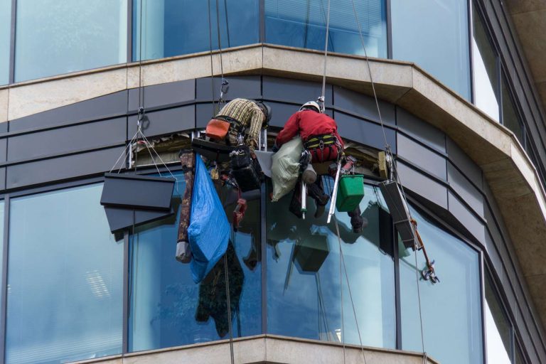 two-workers-doing-some-repair-outside-skyscraper